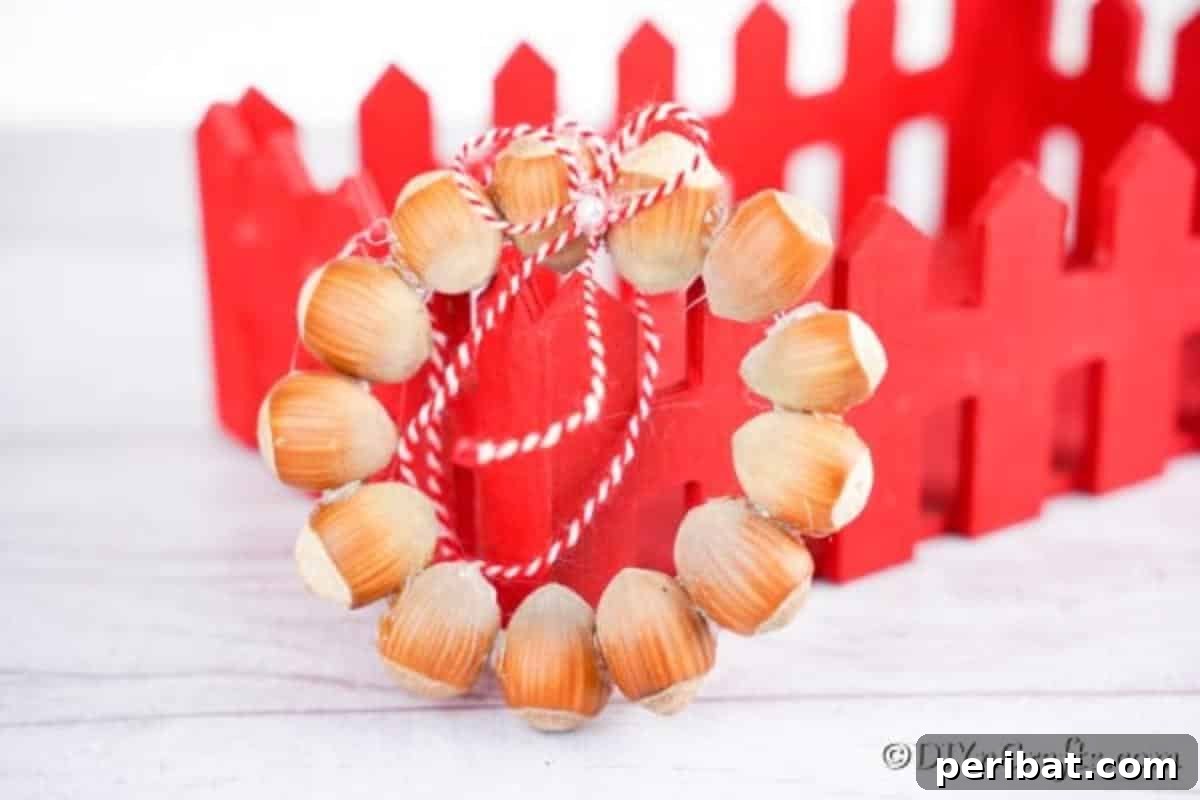 Handmade Rustic Hazelnut Christmas Ornaments 3 A charming rustic hazelnut wreath ornament resting beside a festive red wooden box, highlighting its cozy appeal.