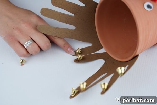 Whimsical Clay Pot Reindeer Christmas Creations 24 Gluing jingle bells onto the horns of a reindeer flower pot decoration
