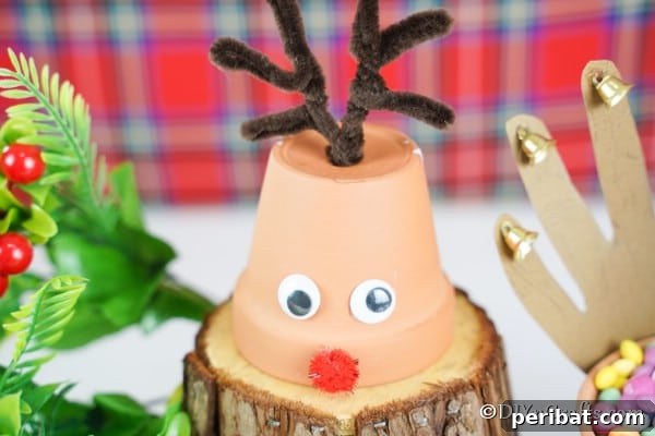 Whimsical Clay Pot Reindeer Christmas Creations 25 Up close picture of a single small reindeer Christmas decoration on a piece of wood
