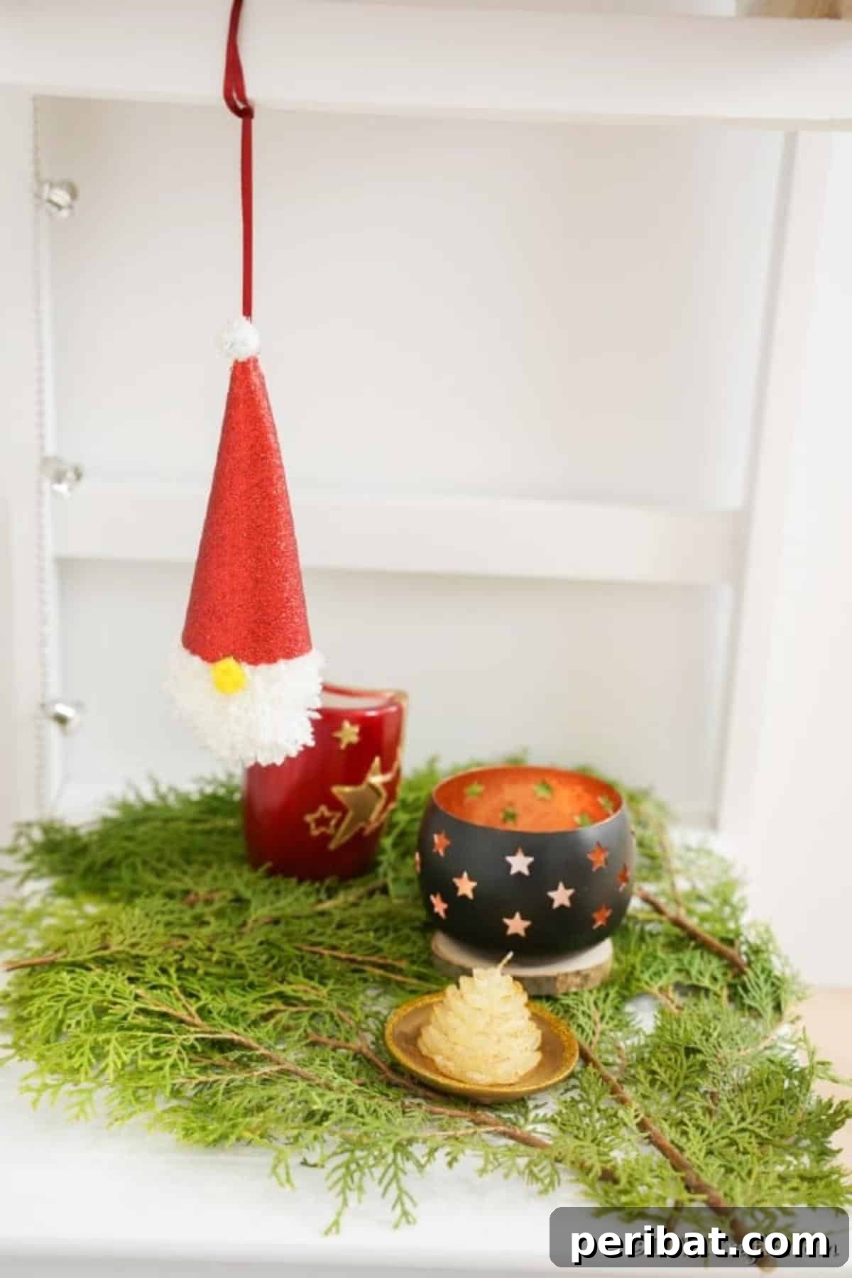 Cozy Pom-Pom Gnomes: Whimsical Holiday Tree Charms 15 A Christmas gnome ornament hanging on a shelf above holiday decorations