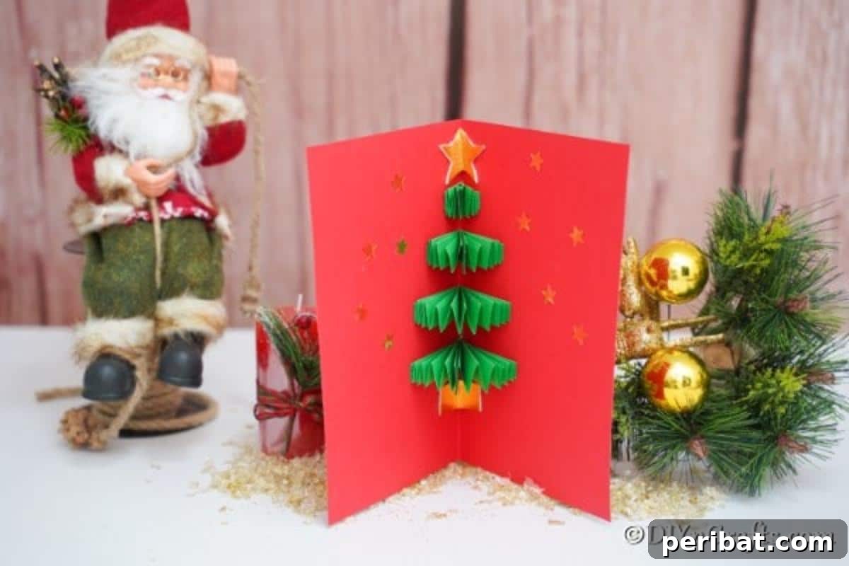 A 3d Christmas tree card sitting displayed on a wooden surface with a santa in the background
