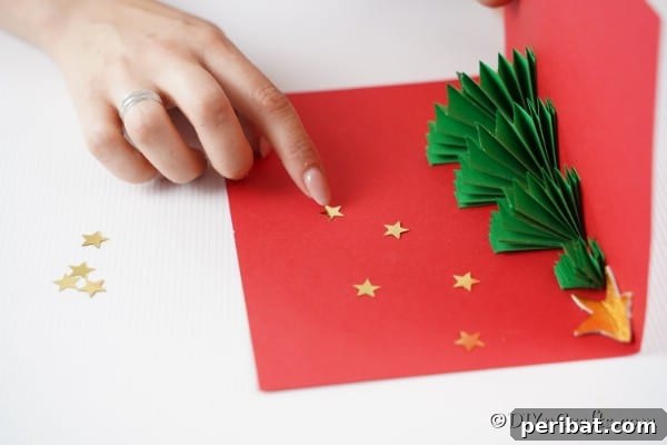 Adding gold star stickers to the inside of the 3D Christmas tree card