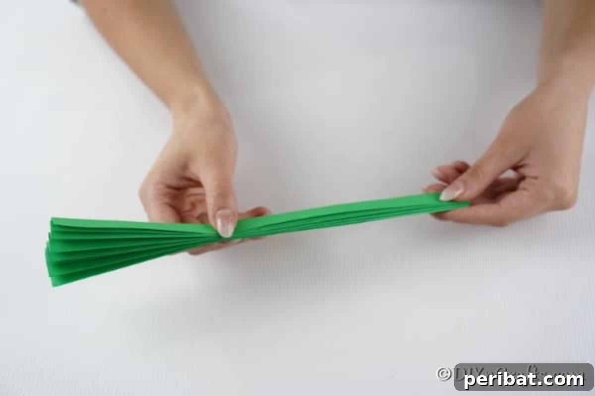 Folding a piece of green paper to create a tree for a 3d card