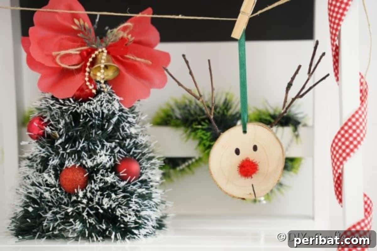 A small Christmas tree placed next to a rustic wood slice reindeer ornament on a festive mantle or shelf.