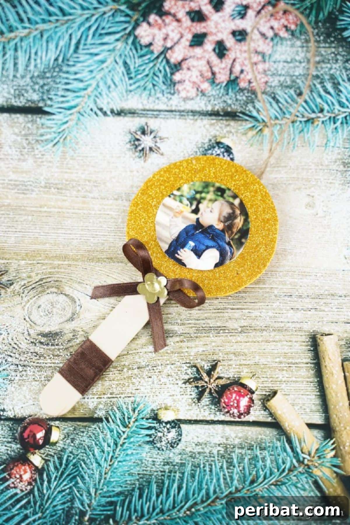 Sweet Memories: Craft Stick Photo Lollipops 4 A beautifully crafted craft stick lollipop photo ornament resting on a rustic wooden surface, surrounded by elegant blue and silver holiday decorations, demonstrating its versatility.