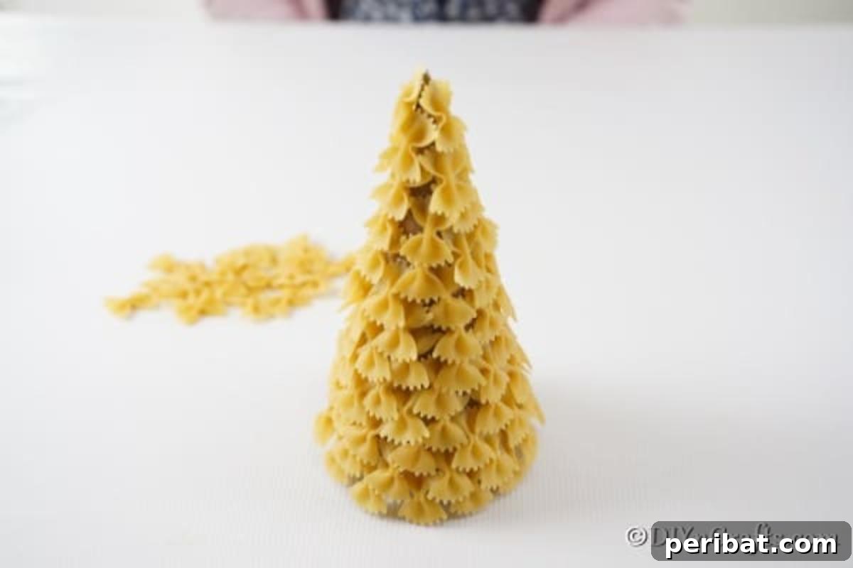 Creative Pasta Christmas Ornaments 12 A meticulously covered pasta Christmas tree, awaiting its transformation with paint, showcasing the intricate texture before its final color.