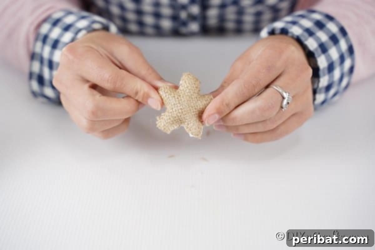 Creative Pasta Christmas Ornaments 15 Artfully covering the styrofoam star with burlap, a key step in preparing the charming topper for your pasta Christmas tree.
