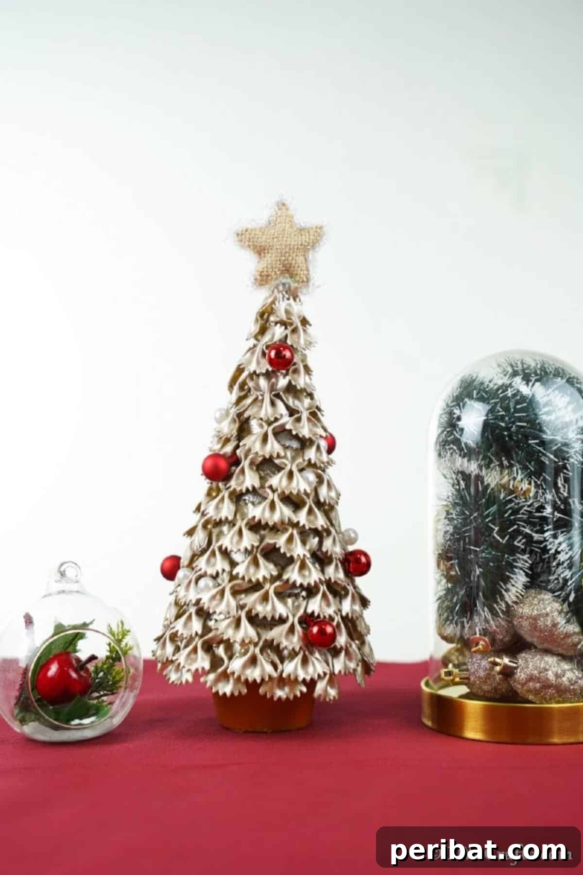 Creative Pasta Christmas Ornaments 18 A perfectly completed Christmas tree crafted from pasta, elegantly displayed on a vibrant red counter, radiating festive charm.