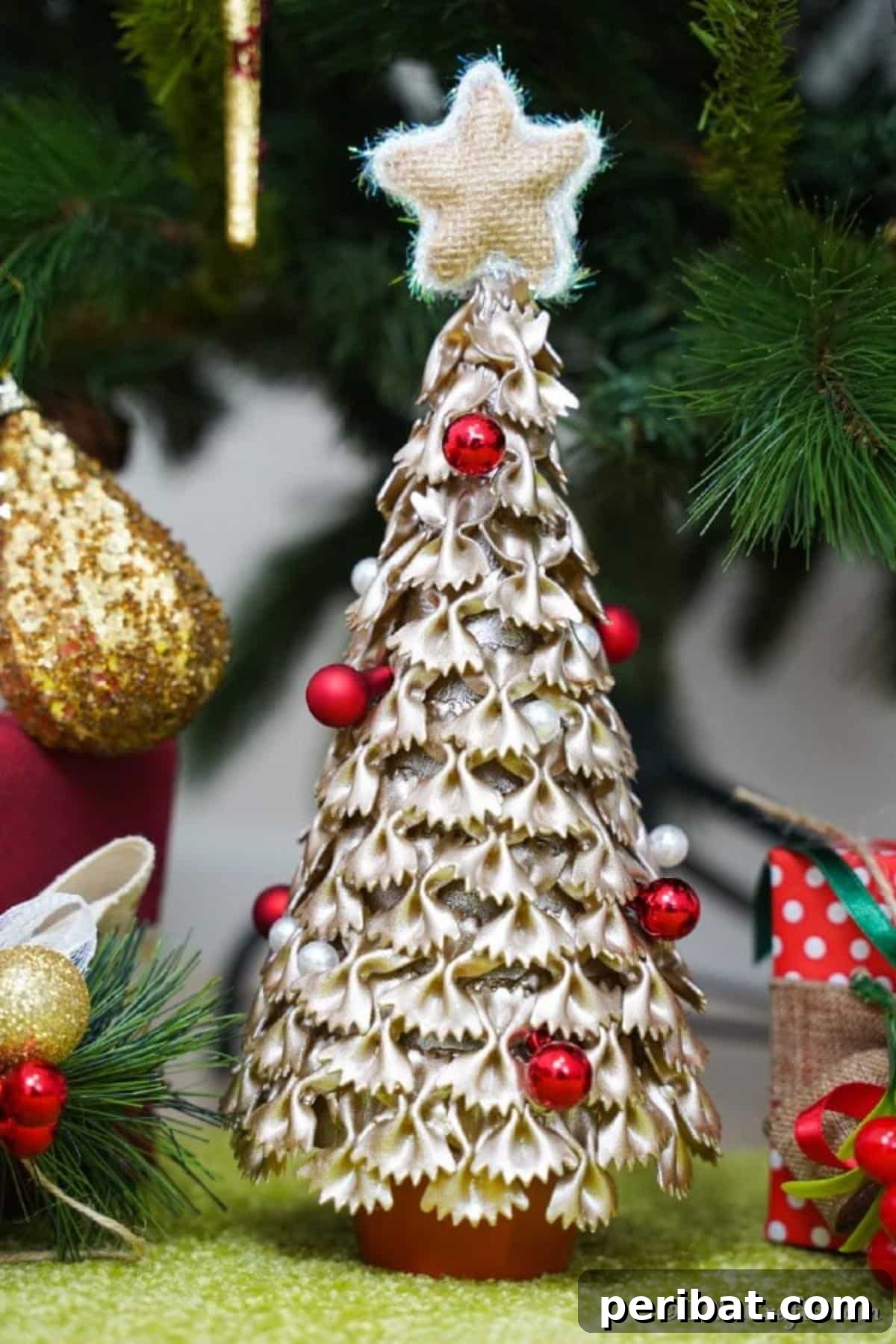Creative Pasta Christmas Ornaments 4 An up-close detailed picture of a pasta Christmas tree, highlighting the intricate texture and craftsmanship, set against a vibrant green surface.