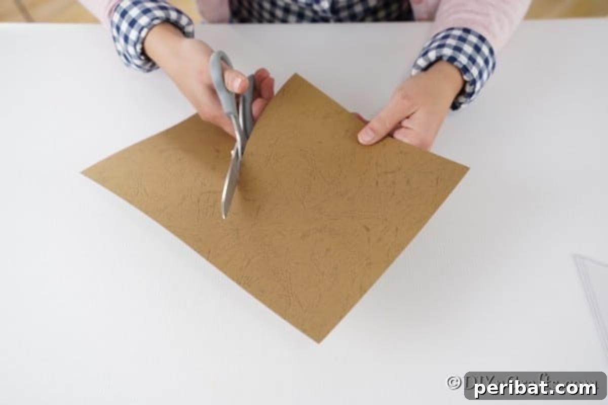 Creative Pasta Christmas Ornaments 9 Precisely cutting an arc shape from a piece of cardstock, an essential step in crafting the cone base for a pasta Christmas tree.