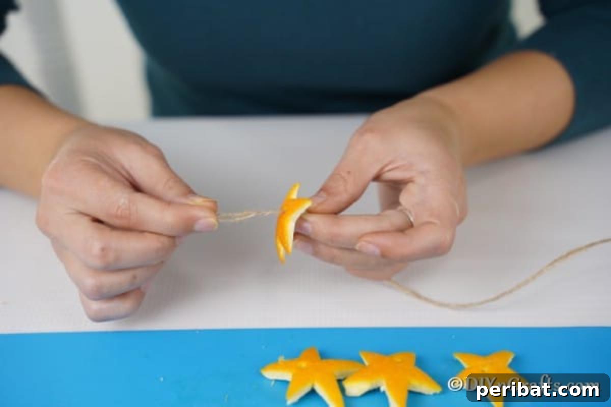 Rustic Chic Orange Peel Star Winter Garland 11 Threading orange stars onto a thread for a simple Christmas garland
