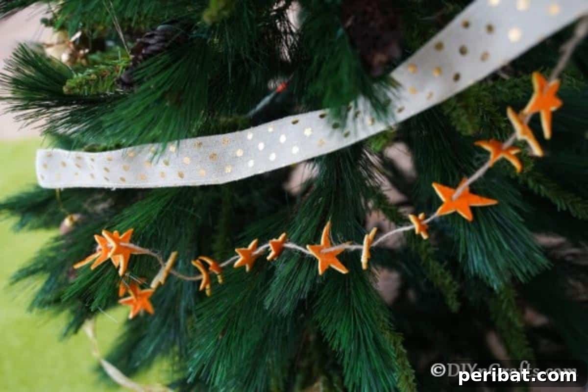 Rustic Chic Orange Peel Star Winter Garland 12 Up close picture of an orange star garland hanging on a Christmas tree