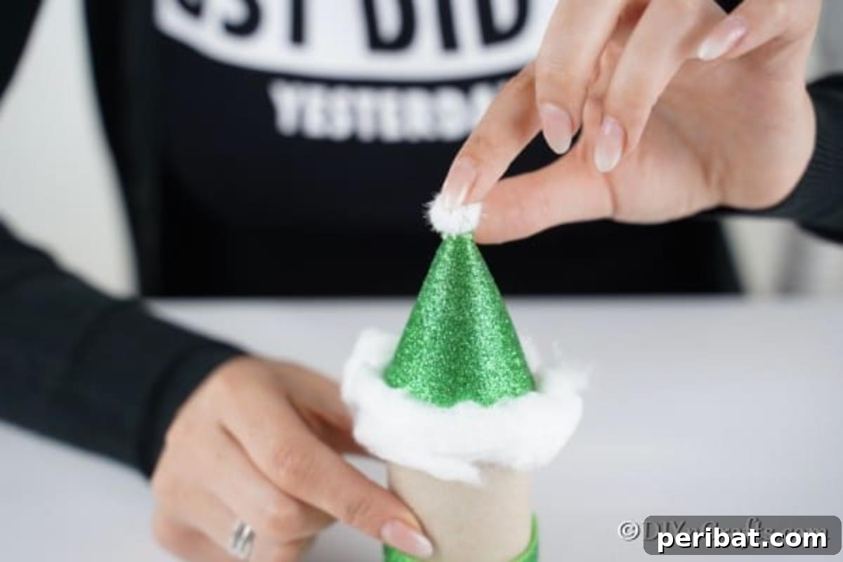 Upcycled Toilet Roll Santa Snowman and Elf for Kids 25 Decorating the elf hat by attaching a small white pom-pom to the top and fluffy cotton around the brim for a festive look.