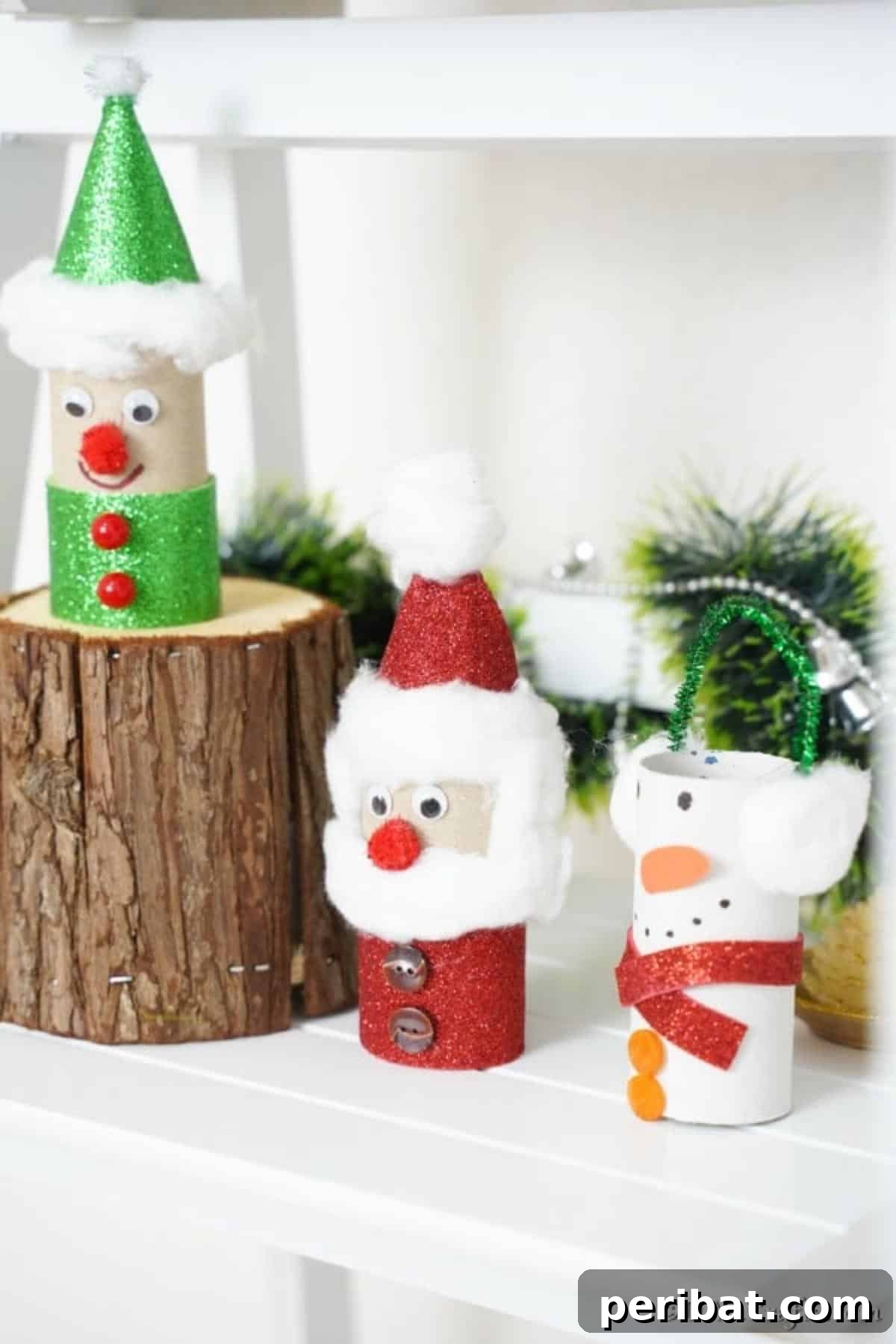 Upcycled Toilet Roll Santa Snowman and Elf for Kids 27 A festive display of three toilet paper roll Christmas crafts (Santa, Snowman, Elf) arranged decoratively on a mantle.