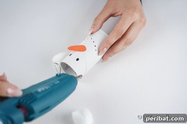Upcycled Toilet Roll Santa Snowman and Elf for Kids 29 Gluing on cotton balls for ears on the snowman paper roll