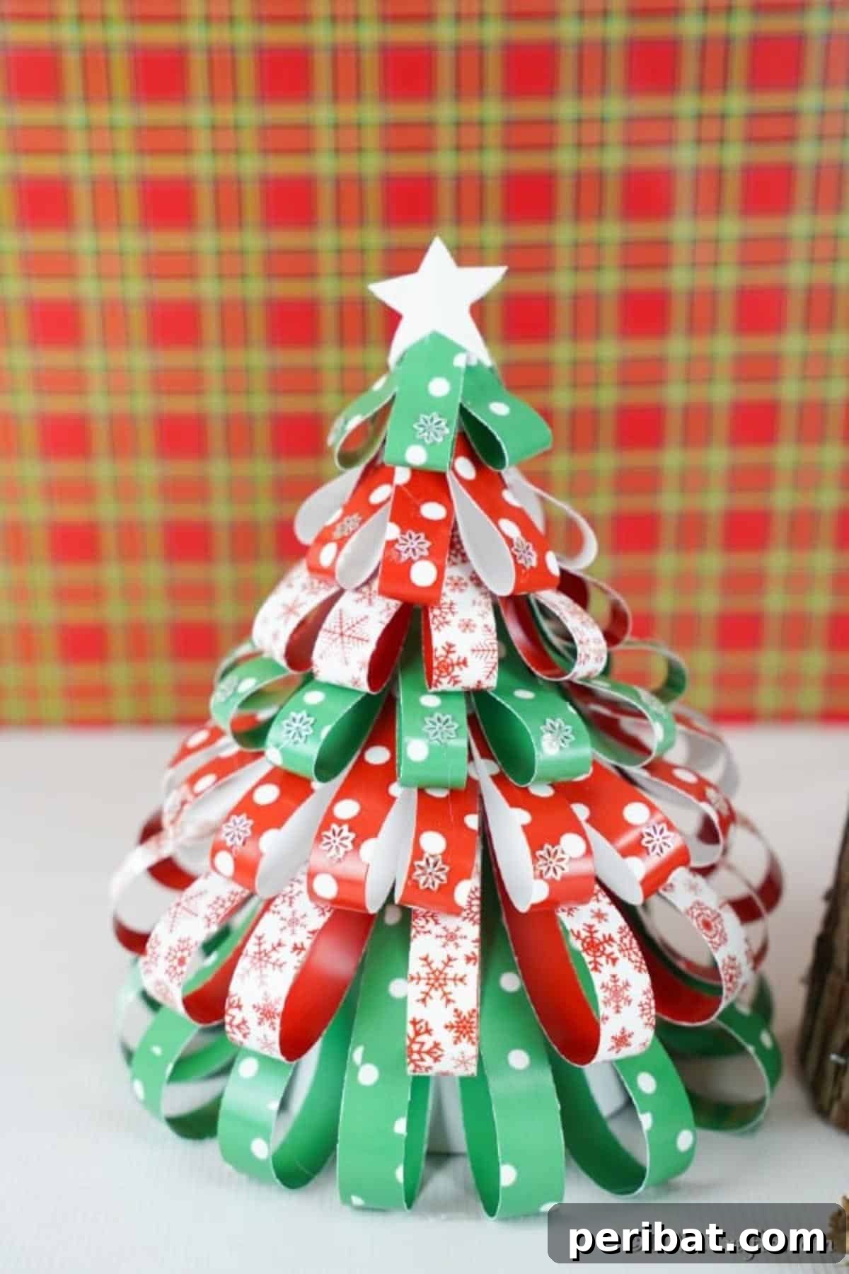 Festive Paper Strip Christmas Tree Delight 17 A mini paper strip Christmas tree decoration in front of a plaid background