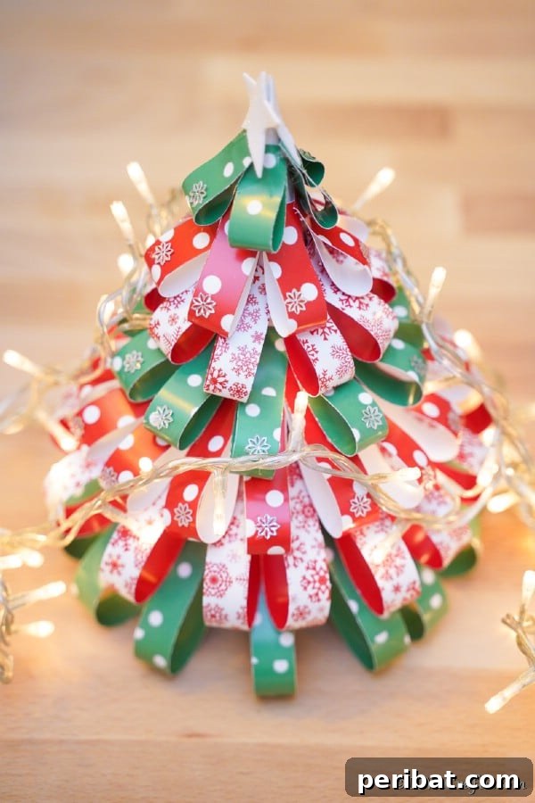 Festive Paper Strip Christmas Tree Delight 18 A paper strip Christmas tree on a table with christmas lights around it