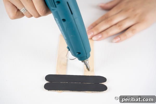 Gluing black craft sticks to the ornament