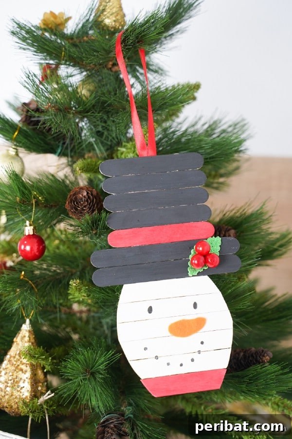 Craft stick snowman hanging on a Christmas tree