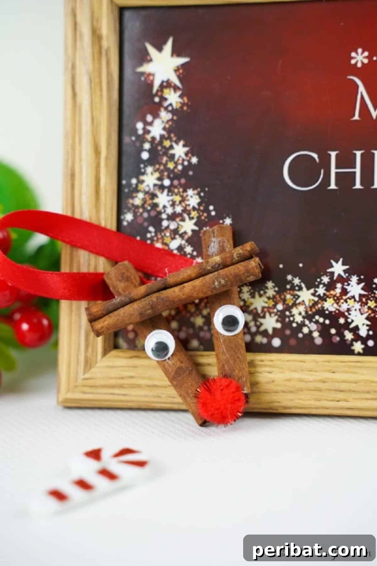 Cinnamon stick reindeer ornaments propped against a holiday sign