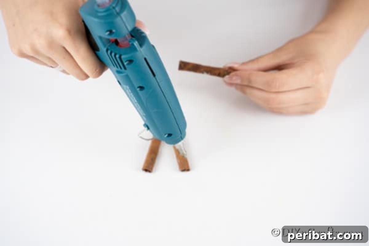 Gluing the cinnamon sticks together to make reindeer ornaments