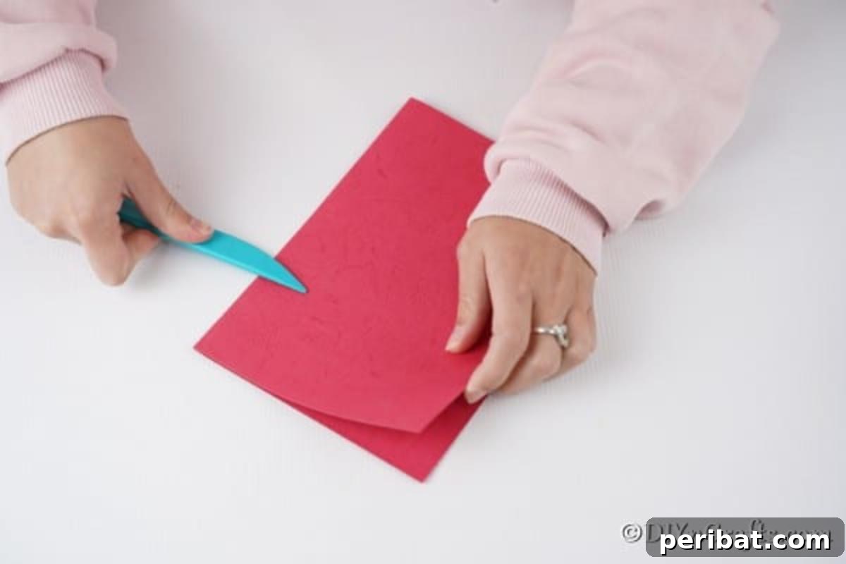 Folding the red cardstock in half for a 3D Christmas card