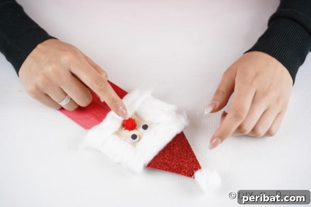 Finishing the Santa Claus face on your popsicle stick ornaments