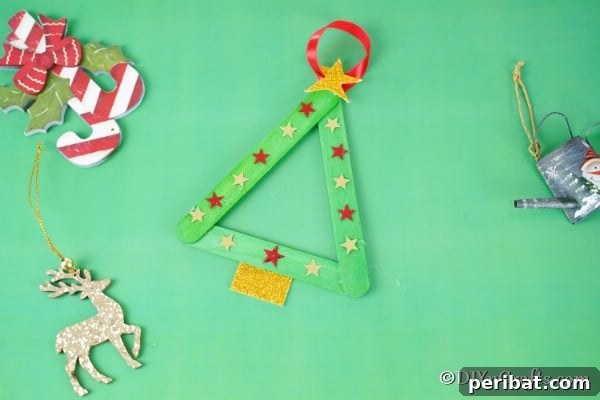 Craft stick Christmas tree ornament on a green table