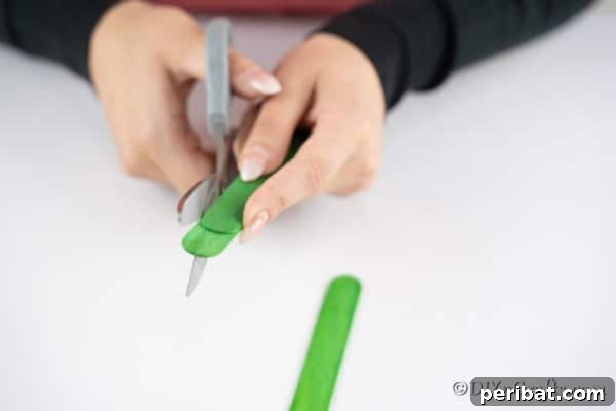 Painting craft sticks green to make a holiday tree