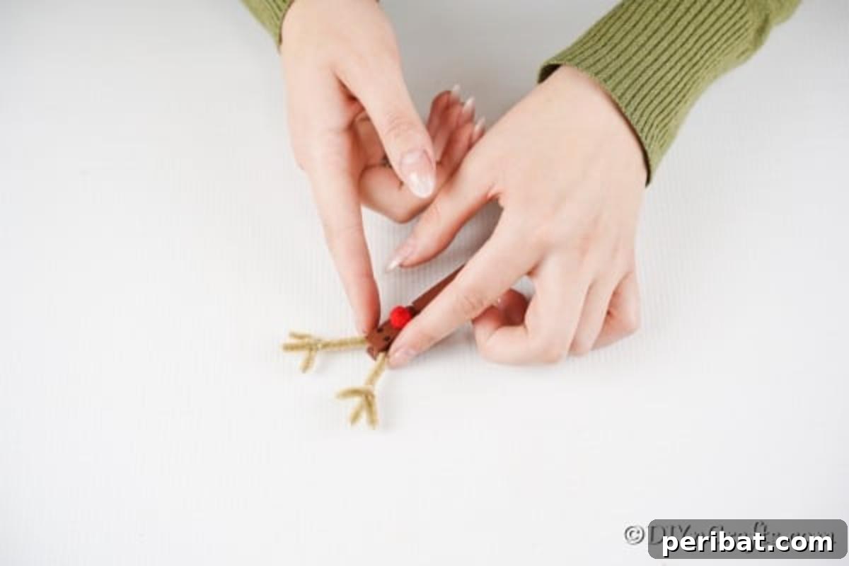 Transform Clothespins Into Adorable Reindeer Ornaments 12 Attaching the antlers to the clothespin reindeer ornaments