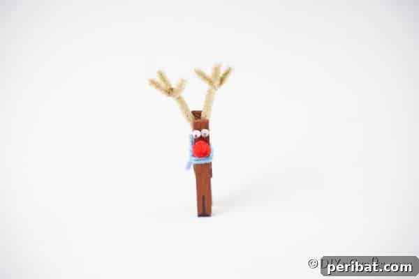 Transform Clothespins Into Adorable Reindeer Ornaments 16 A clothespin reindeer ornament on a white surface