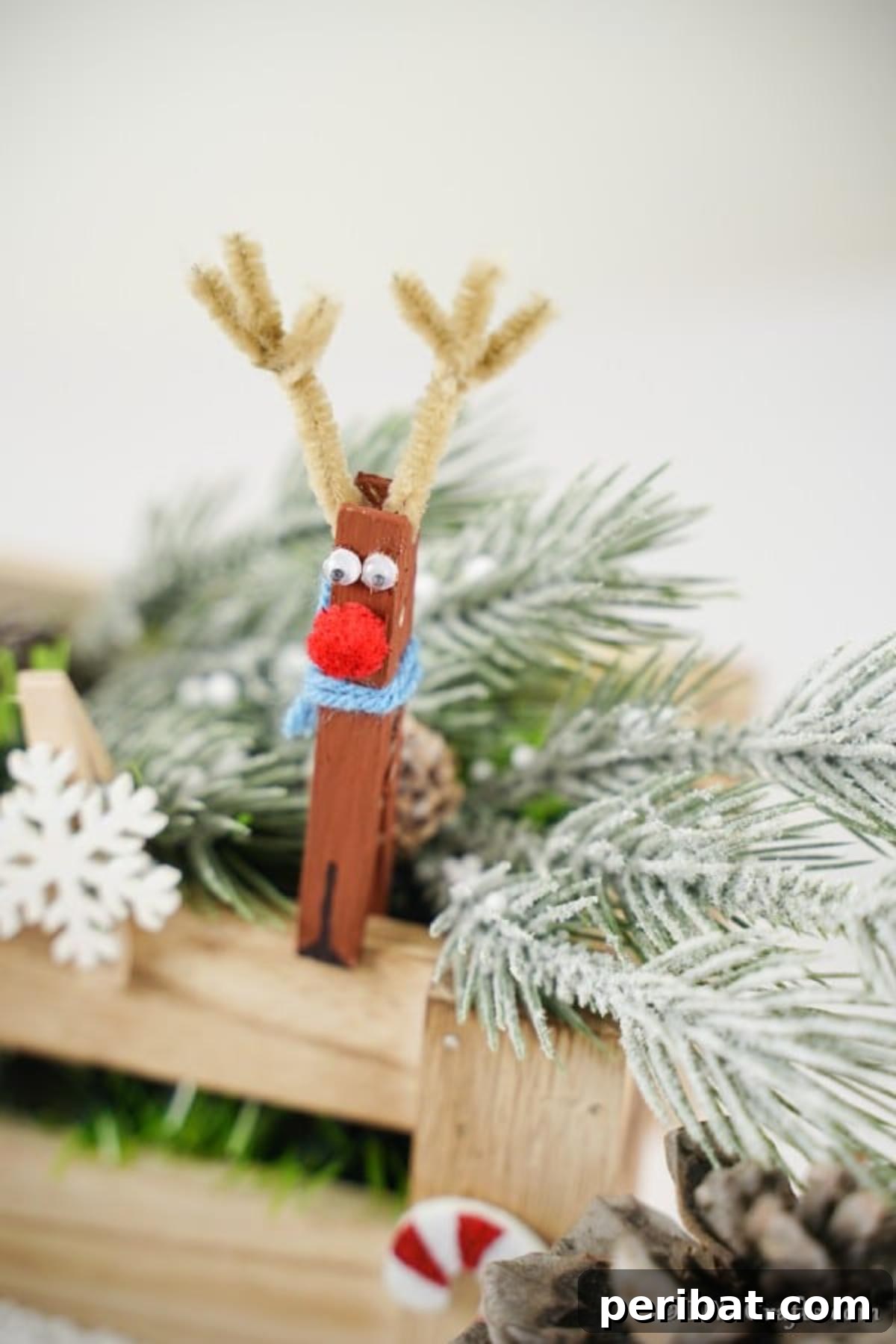 Transform Clothespins Into Adorable Reindeer Ornaments 4 Reindeer clothespin ornaments on display next to holiday greenery