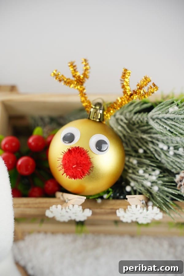 Rudolph's Dazzling Christmas Tree Bauble 18 Reindeer Christmas ball ornament displayed on a shelf with holiday greenery, showcasing the ornament from another angle.
