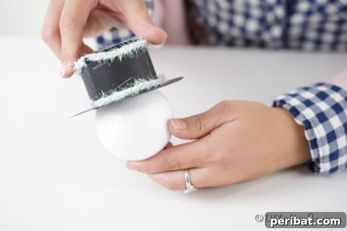 Gluing the top hat to the snowman face