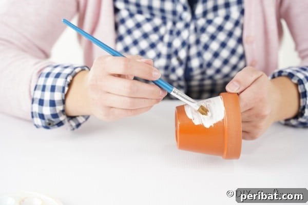 Painting the clay pot for snowman decoration