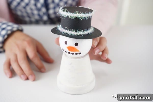 Gluing the snowman head onto the snowman decoration