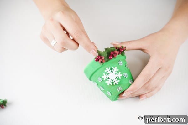 Craft Your Own Adorable Christmas Bell Ornaments 18 Gluing holiday berries and leaves onto bottom of flower pot Christmas bell decoration