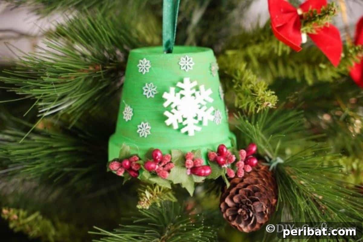 Craft Your Own Adorable Christmas Bell Ornaments 3 A beautifully decorated DIY Christmas bell, crafted from a clay pot, hanging elegantly amidst the branches of a Christmas tree