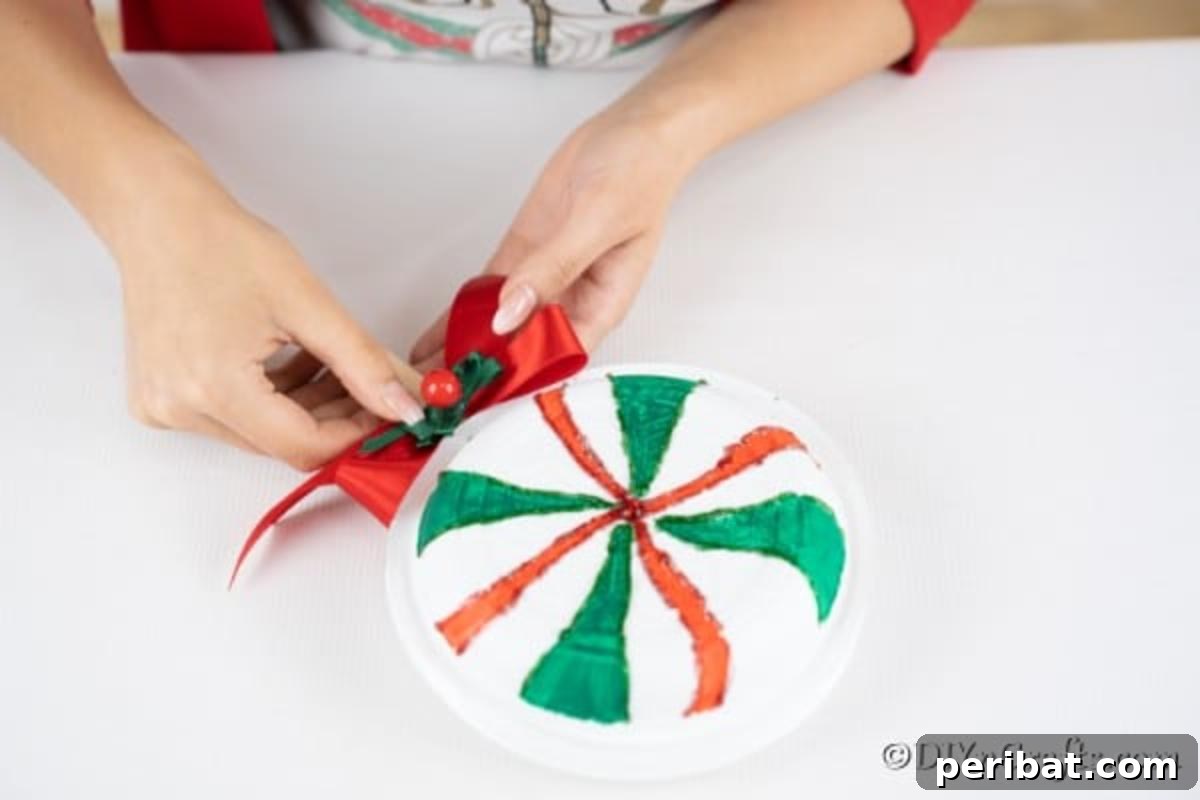 Gluing the bow in place on the paper plate giant lollipops decoration