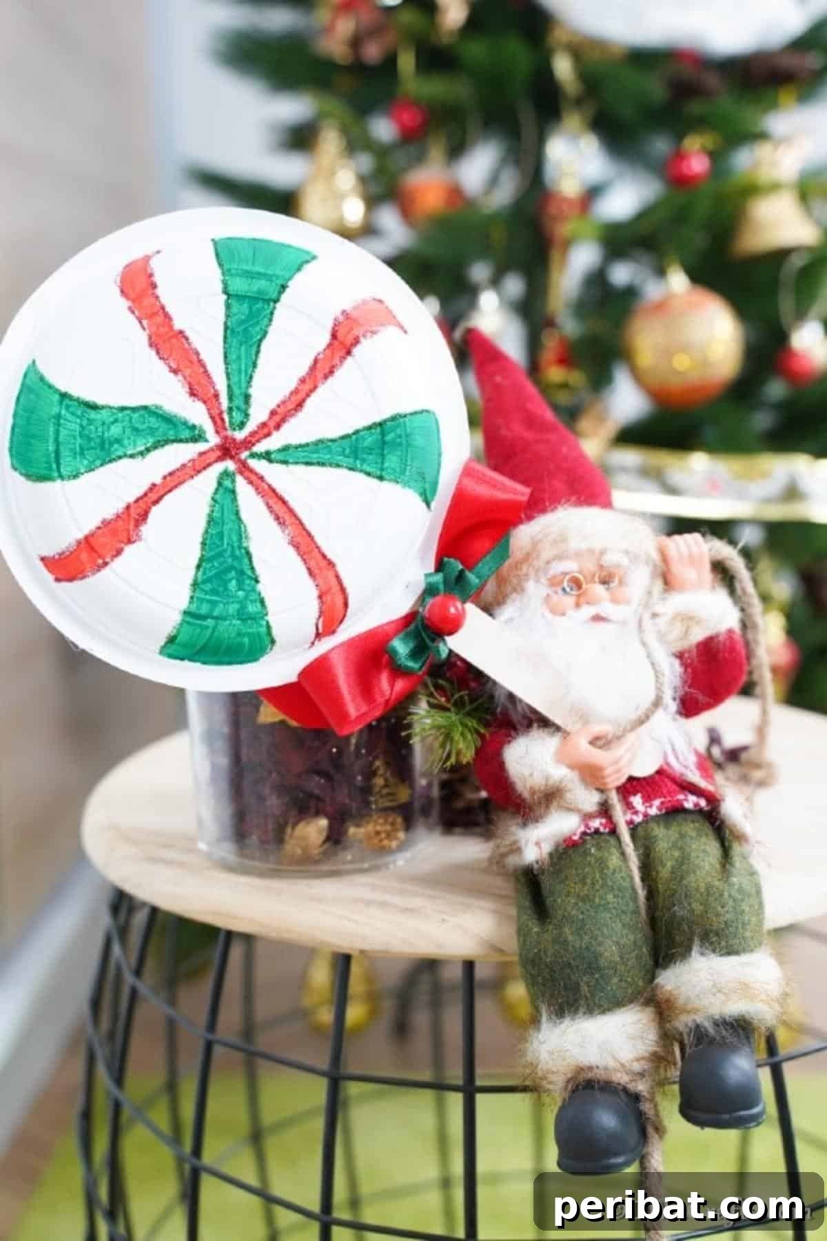 Giant lollipops on a stool with toy Santa in front of the Christmas tree