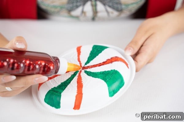 Adding glitter glue to the giant lollipops plates