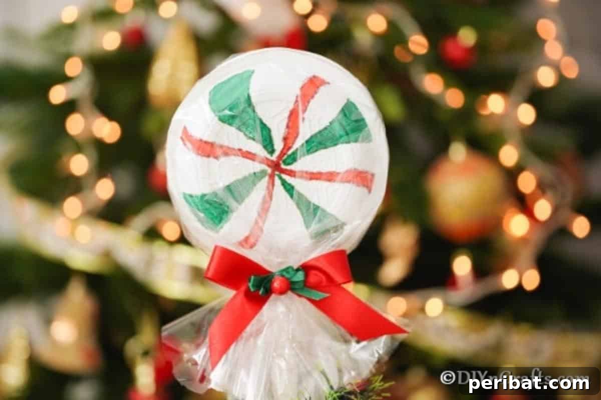 Giant lollipop displayed in front of a Christmas tree, adding festive charm