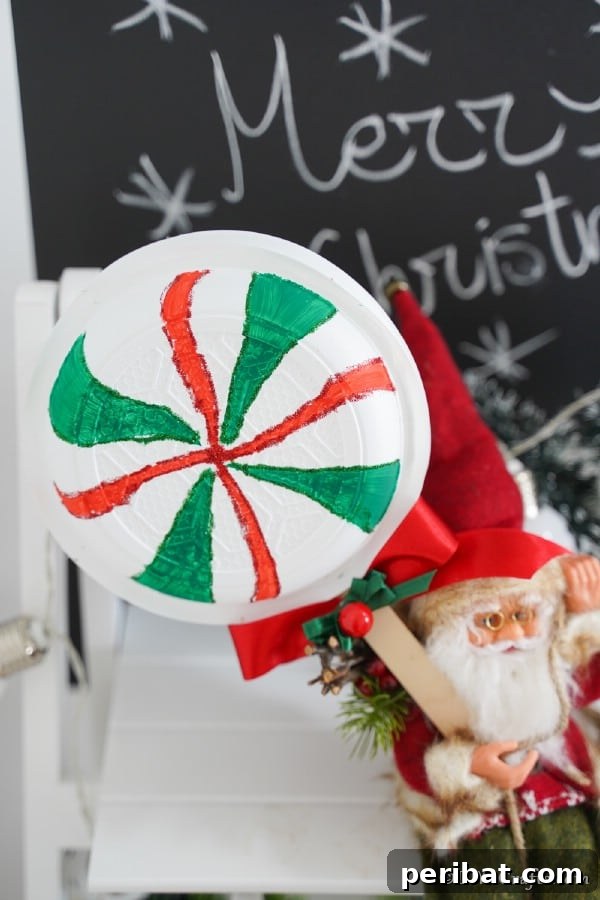 Santa toy holding a giant lollipops decoration up in front of holiday sign