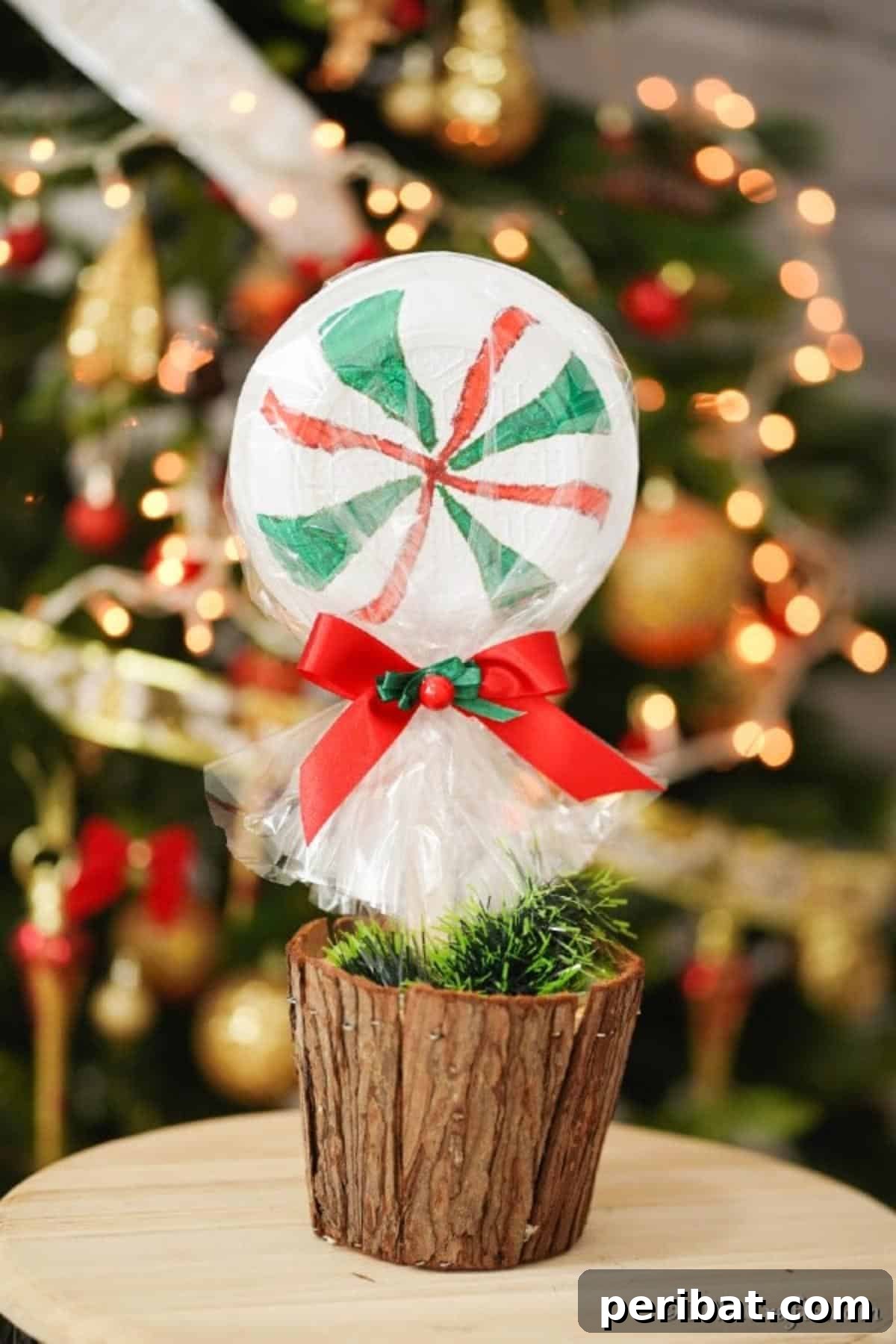 Giant peppermint lollipop in a wooden stump in front of a Christmas tree