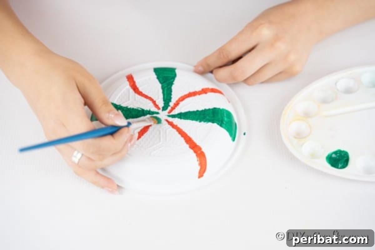 Adding paint lines to plates for making giant lollipops for holiday decor
