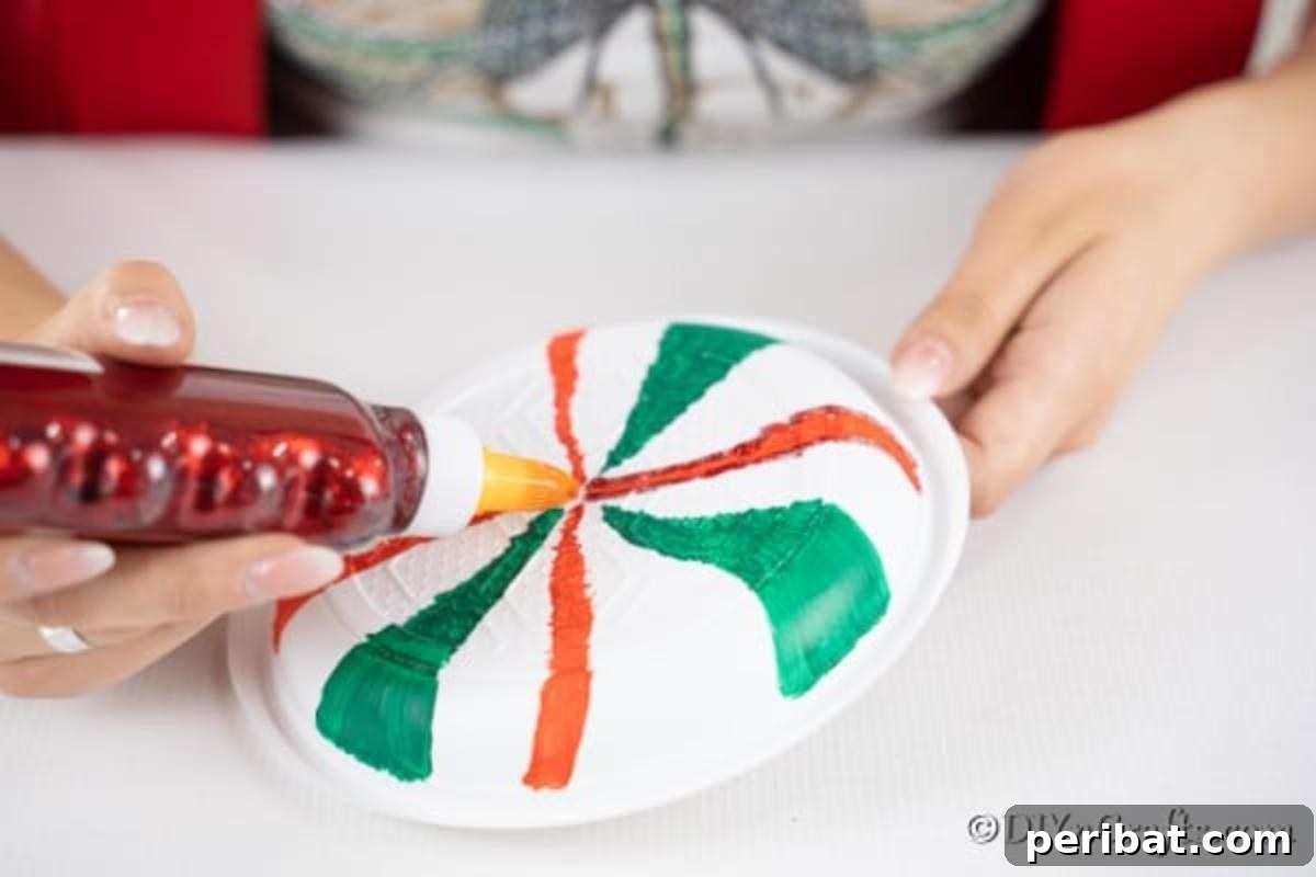 Adding glitter glue to the giant lollipops plates for sparkle