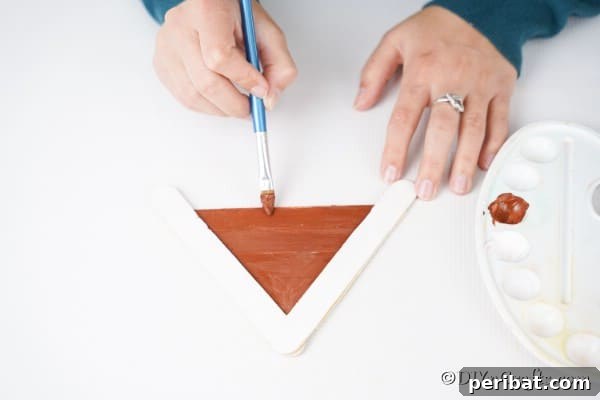 Whimsical Wooden Gingerbread House Charm 22 Painting the roof of the craft stick gingerbread house