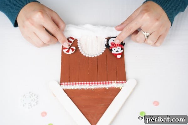 Whimsical Wooden Gingerbread House Charm 26 Adding candy cane and penguins to the gingerbread house craft