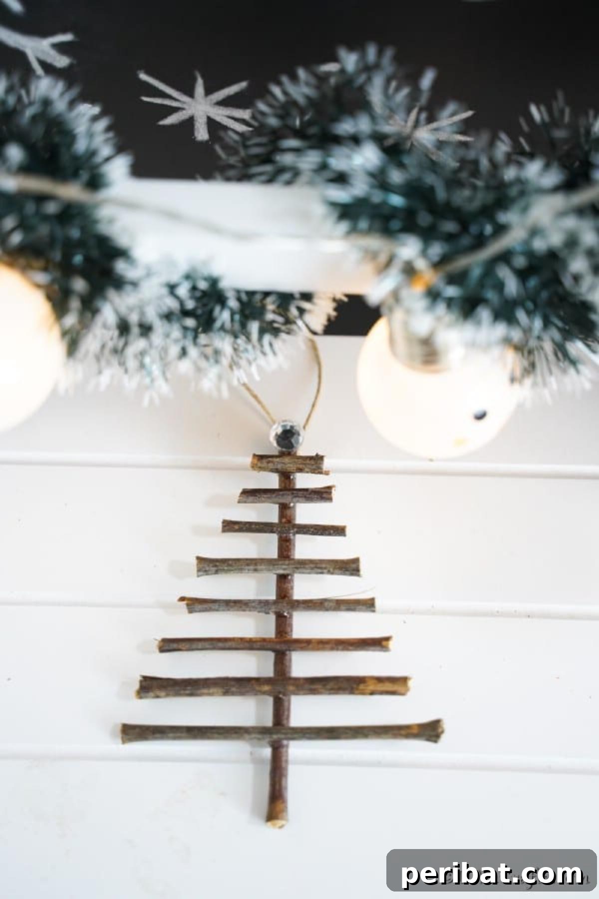 DIY Rustic Twig and Branch Christmas Ornaments 14 A finished rustic Christmas tree shaped ornament resting gracefully on a white table, ready to adorn your tree.