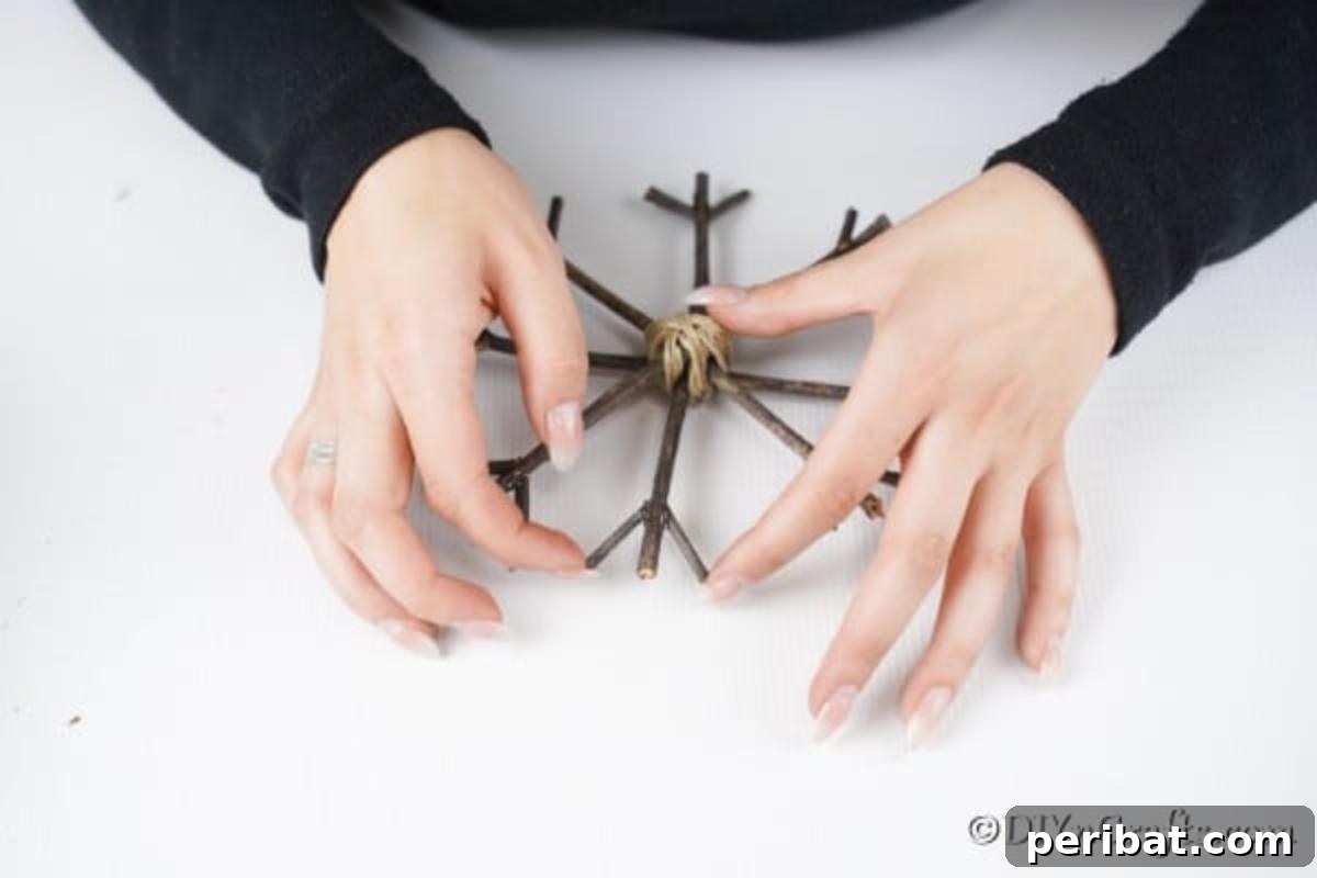 DIY Rustic Twig and Branch Christmas Ornaments 17 Attaching small pieces of twigs to the ends of the main branches to create the intricate pattern of a rustic Christmas snowflake.